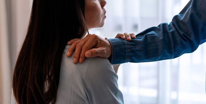 女性の肩に手を置く男性