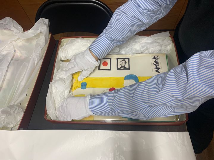 安西水丸事務所で学芸員が作品の入った箱に無酸紙を詰める様子