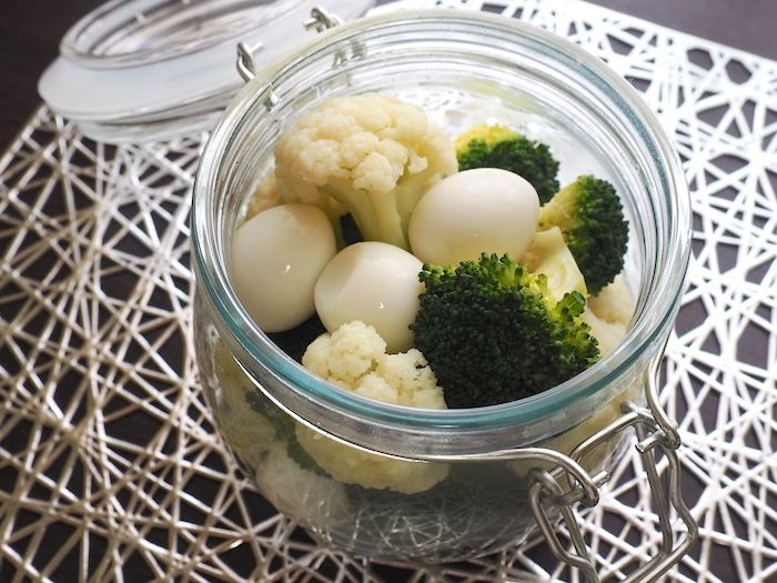 茹でた野菜とうずらの卵を瓶に入れる