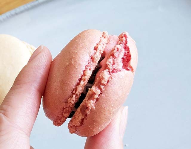 ファミリーマート限定「ラブポーションサーティワン風マカロン」を指でつまんでいる様子