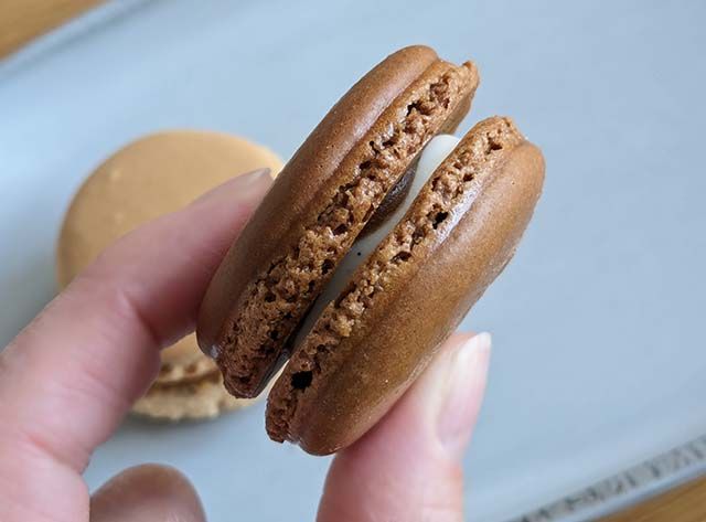 ファミリーマート限定「キャラメルリボン風マカロン」を指でつまんでいる様子