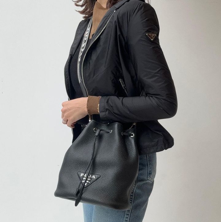 プラダのレザーバッグを持った女性