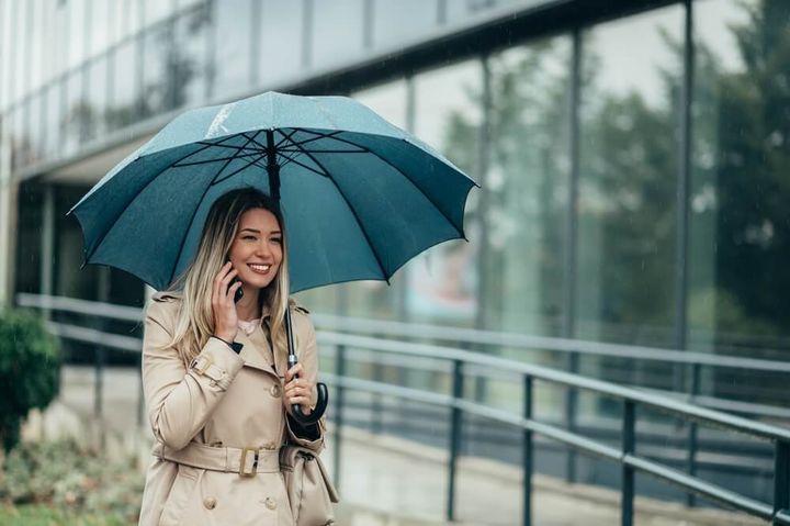 傘を差しながら通話する女性