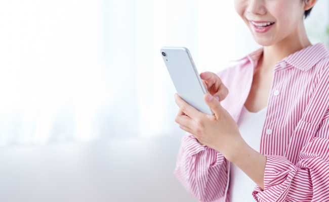 スマホで推しを見る女性のイメージ