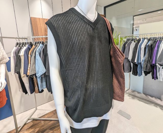 ウォッシャブルメッシュニットベストを着用している