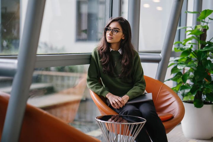 シャツとセーターをレイヤードした女性