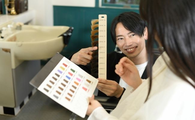 美容室でヘアカラーを選ぶ女性のイメージ