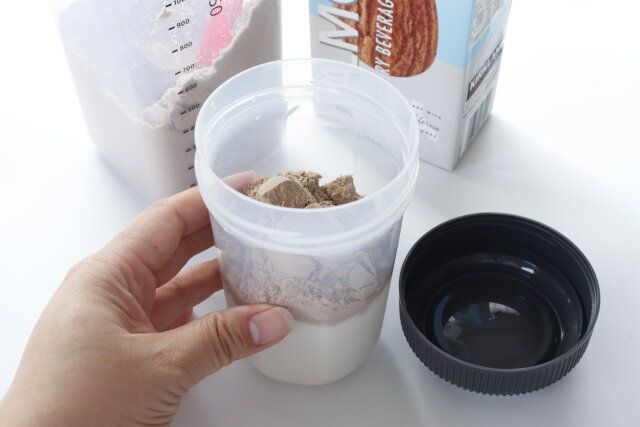 ダイソーのプロテインシェイカー ブラックにプロテインの粉末を入れる