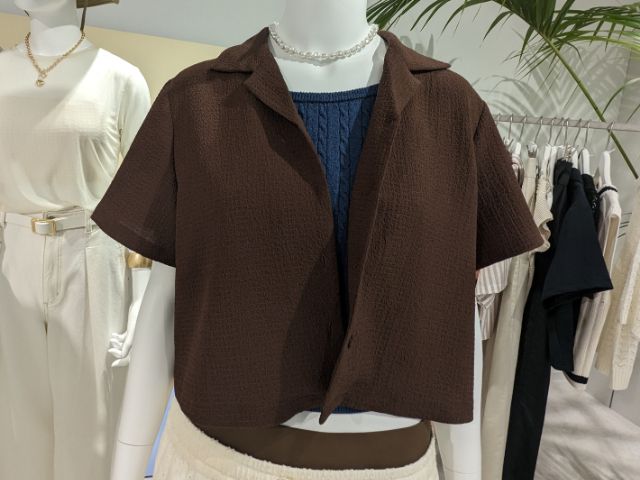 ブラウンのテクスチャーオープンカラーシャツを着用