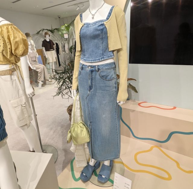 デニムビスチェとデニムスカートを着用