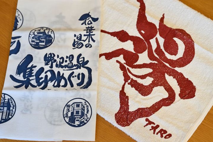 集印デザインのてぬぐいと、岡本太郎がデザインした「湯」のタオル