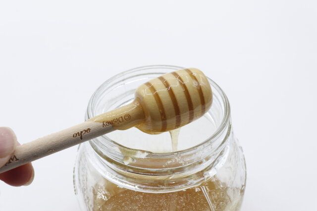 セリアのプーさん 木製はちみつディッパーではちみつをすくう様子