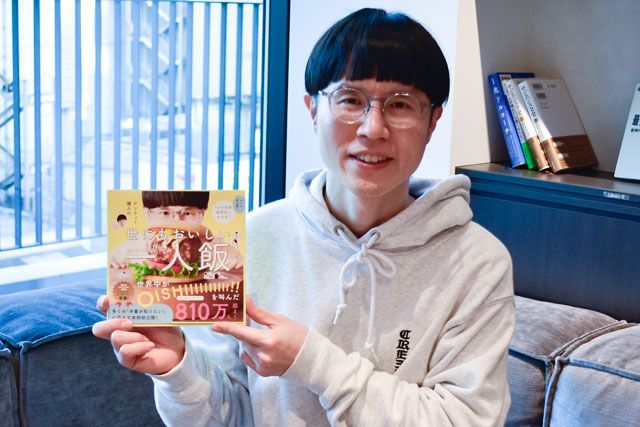 「ケンティー健人の世にもおいしい一人飯」を手に持つケンティー健人さん