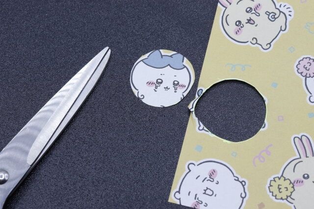 セリアのオリジナルフォトイン カラビナ・キーフックに入れるものをカットする様子