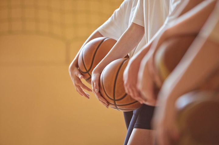 体育館にいる、高校生のバスケットボール選手たち