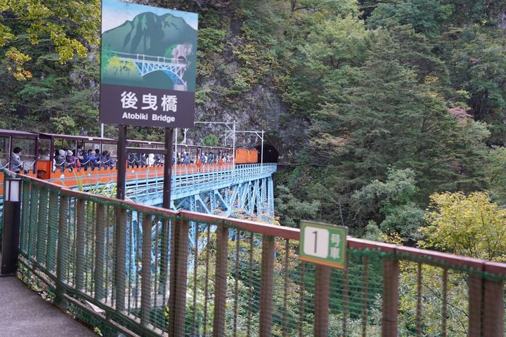 黒薙川に架かる鉄橋を進む黒部峡谷トロッコ電車