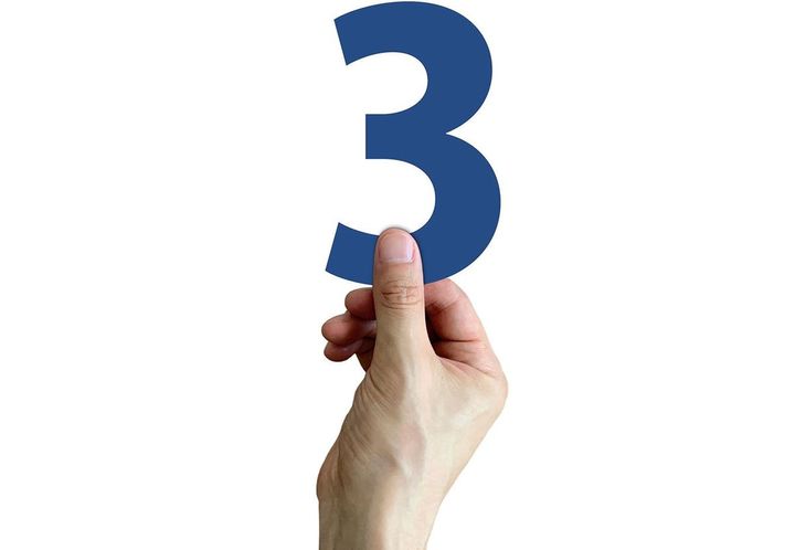 数字の「3」を持つ人の手