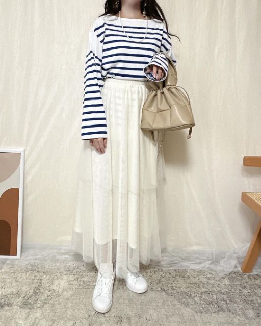 白とネイビーのトップスを着用したコーデ