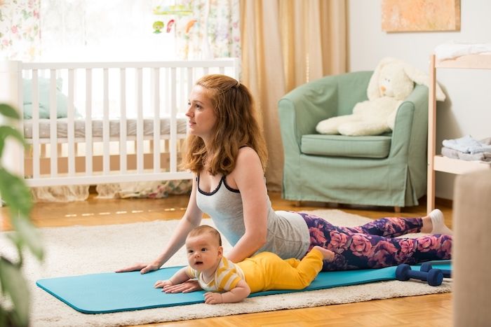 幼い赤ちゃんとストレッチしている女性