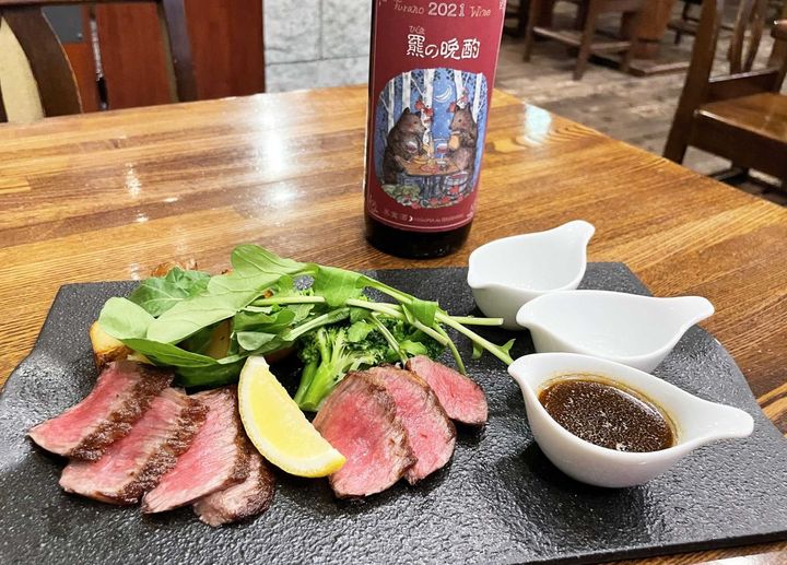 「白老牛のタリアータ」4500円、「羆の晩酌」グラス800円。このワインのラベルは脚本家・倉本聰さんの娘、倉本由美さんが手掛けたものだそう