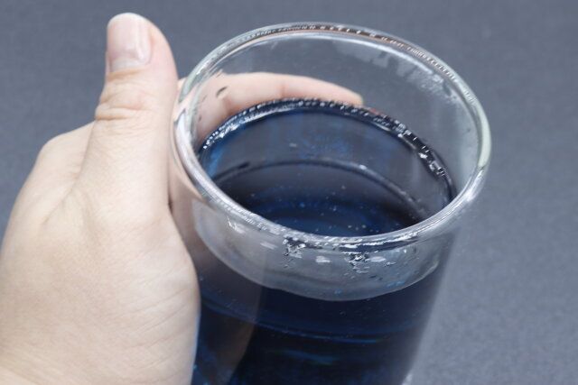 ホットドリンクを注いだダイソーのダブルウォールグラス（円柱型 300mL）を持つ様子