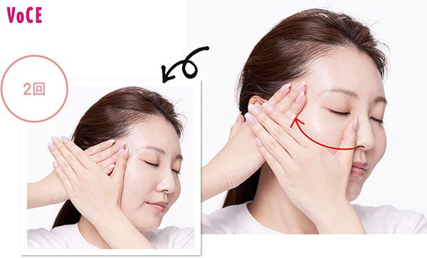 反対側の手を耳前に添え、親指の側面で頬を押し流す