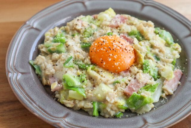 春キャベツのオートミールリゾット レシピ 卵黄をのせ粉チーズと黒こしょうをふる
