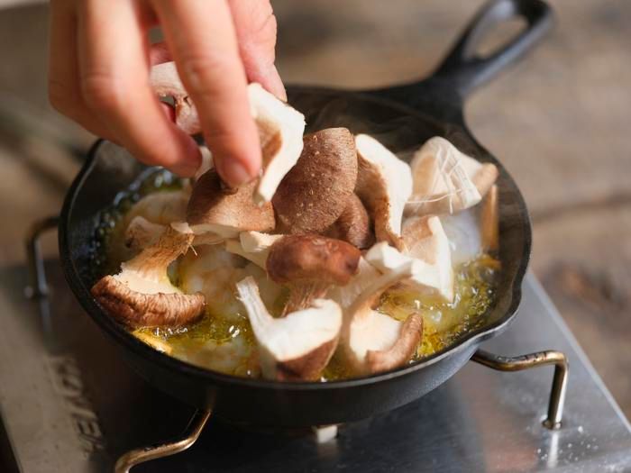 アヒージョにシイタケを加える様子