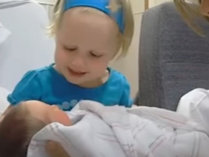 生まれたばかりの弟をかわいがる女の子