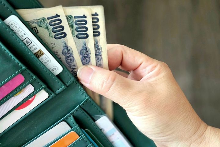 お会計をする男性のイメージ。ゴールド免許は好感度大か？