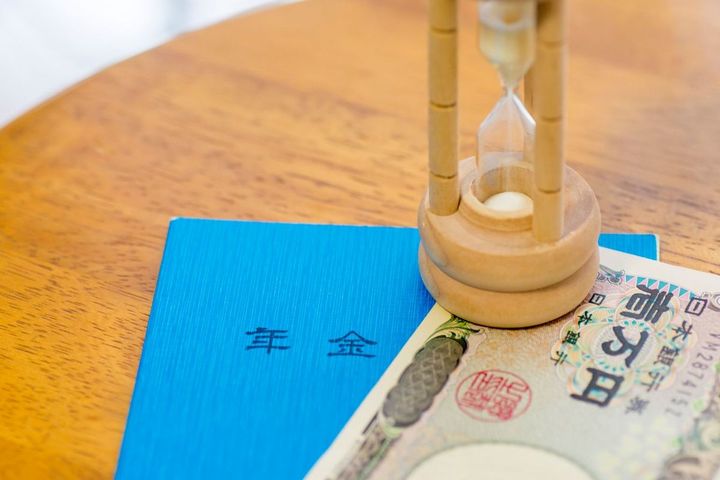 1万円札、年金手帳と砂時計