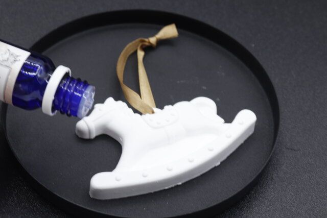 セリアのアロマストーン木馬にアロマオイルを垂らす様子