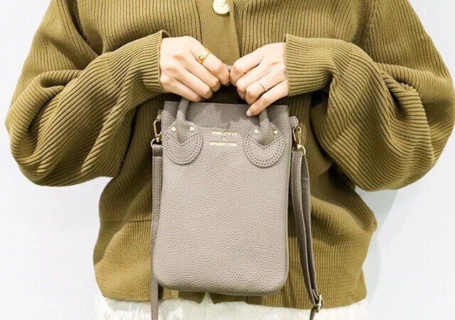 ヤングアンドオルセンのスマホショルダー TAUPEを持った様子