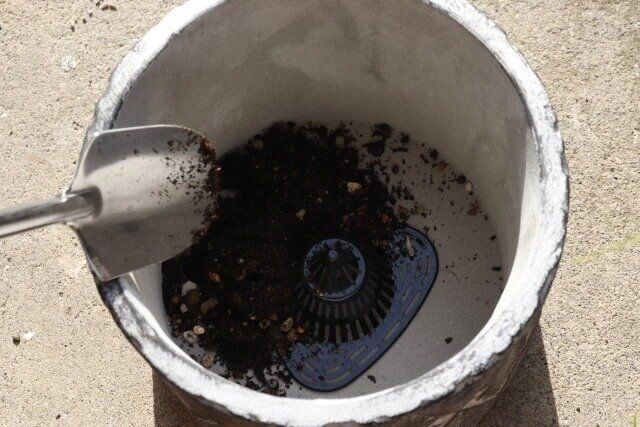 ダイソーの鉢底ネット（7.1cm×7.5cm×4.5cm、6個組）を鉢にセットして土を入れる様子