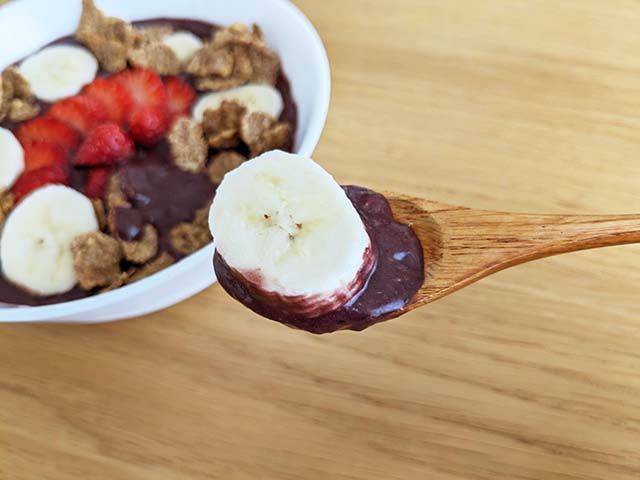 「フルッタフルッタ アサイーピューレ ガラナシロップ入り」を使ったアサイーボウルをスプーンですくっている様子