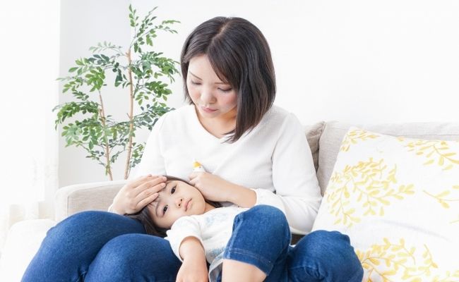 子どもの体調を確認する女性