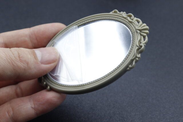 セリアのミニチュア ウォールミラー オーバルの剥離フィルムを剥がした様子