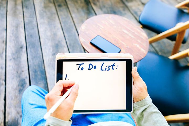top view of man hands writing to do list on digital tablet