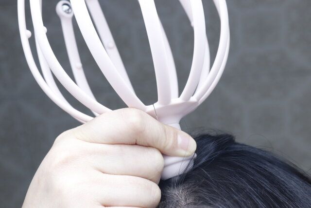 スリーピーのツボ押しスカルプケアの持ち手部分でマッサージする様子
