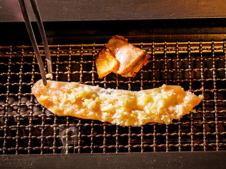 六本木『鶏焼き肉 囲』の「ねぎ塩胸肉」を焼いている様子
