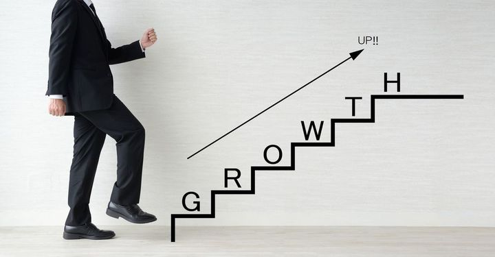 描かれた成長の階段を上ろうとしている男性