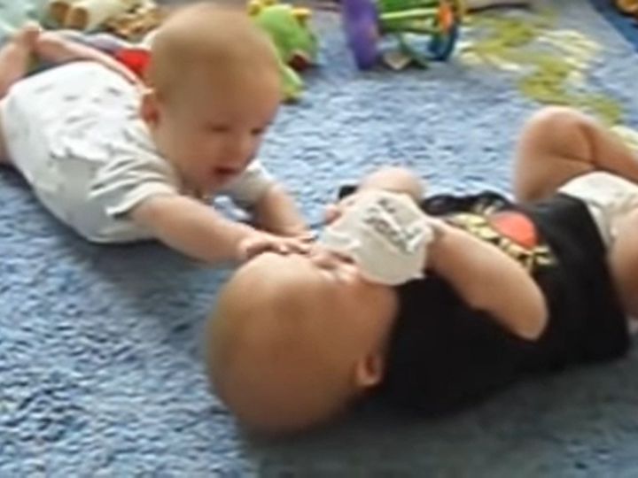 ビニール袋を取り合う2人の赤ちゃん