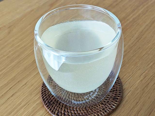 グラスに注がれた炭酸飲料がテーブルに置かれている様子