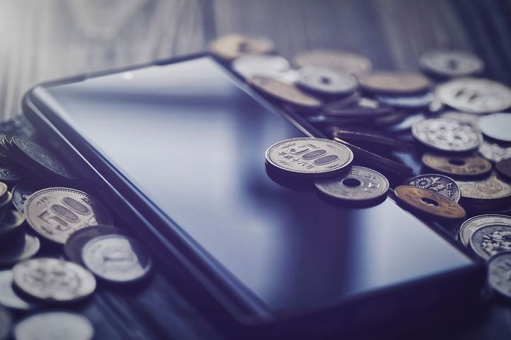 スマホの周りに散らばった小銭