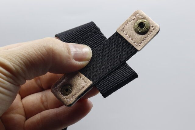 セリアのリュックのヒモ固定バンドをリュックの紐に巻き付ける様子