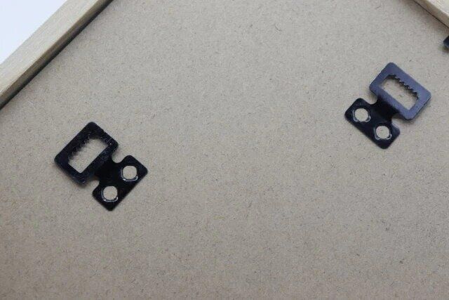 ダイソーのインテリアフォトフレームの背面にはフックを引っ掛けるための金具がある