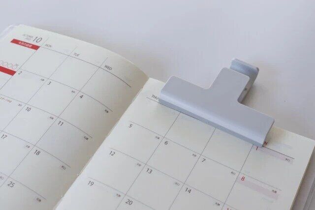 セリアのスマホが立てられるスタンドクリップ ワイドで手帳を挟んだ様子