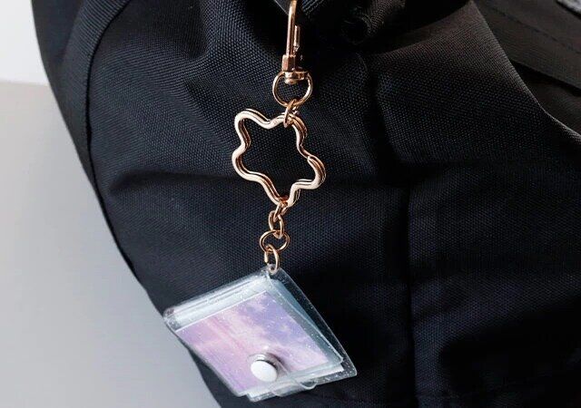 ダイソーのアルバムキーホルダー（3.3cm×4.3cm、16ポケット、星リング付）をリュックサックに吊り下げた様子