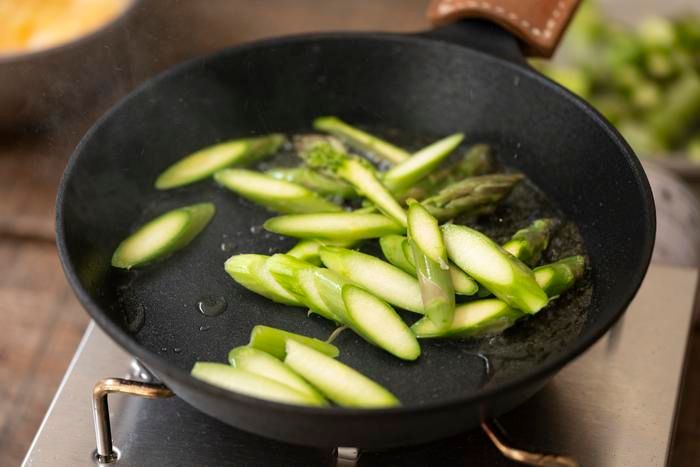 スキレットでアスパラガスを炒める様子