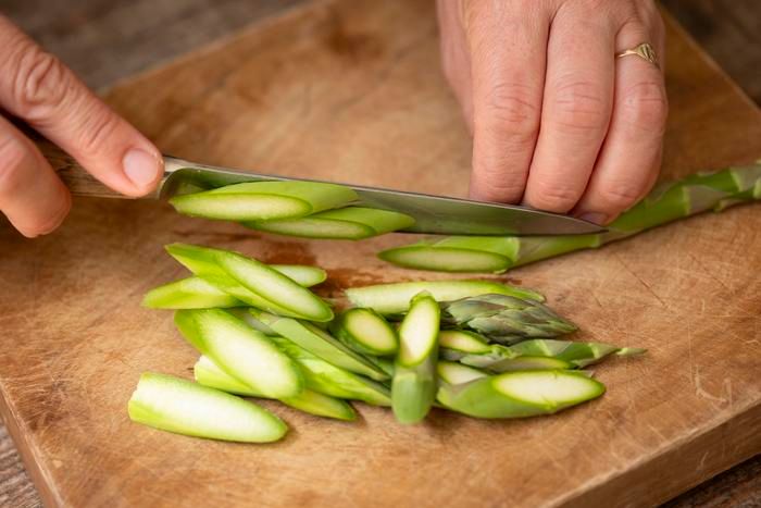 アスパラを斜め薄切りにしている様子